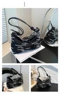 Detail of black tote bag with colorful zigzag embroidery and knotted shoulder strap