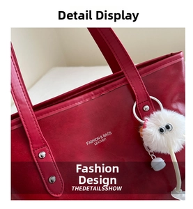 Detail of dark red faux leather tote bag showing silver rivets and a white plush charm