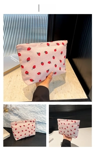 Detailed view of pink corduroy strawberry print makeup pouch with secure zipper closure