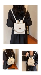 Detail view of white bow backpack with thick metal chain and glossy leather finish
