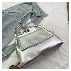 Macro detail of silver metallic tote with leather texture and silver chain strap details