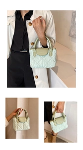 Close-up of mint green quilted bucket bag featuring a top handle and logo detail