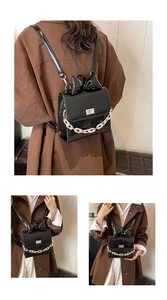 Detail of black patent leather mini backpack featuring bow decor and silver chain accent