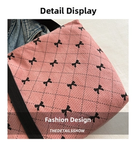 Vue détaillée du tissu en velours rose avec motifs de nœuds noirs sur le sac cabas