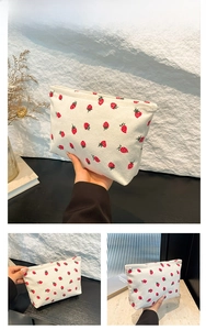 Detail view of white corduroy shoulder bag with red strawberry print and soft texture