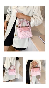 Detail of pink quilted bucket bag showing rhombus texture and metal logo lettering