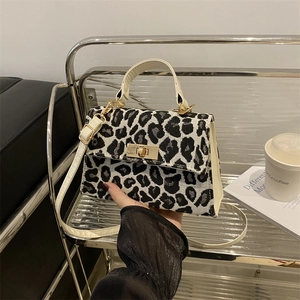 Fashionable leopard print crossbody bag with gold twist lock and elegant top handle