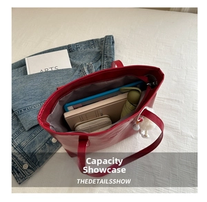 Detail view of large red tote bag interior showing spacious storage for tablet and books