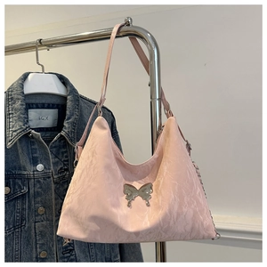 Detailed shot of pink pleated nylon shoulder bag with silver butterfly metal buckle