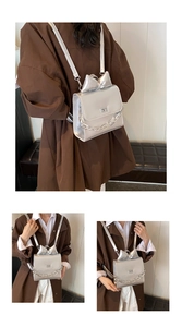 Three-way view of a silver metallic backpack with a large bow and chunky chain detail