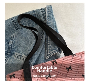 Détail du sac cabas rose en velours côtelé avec motifs nœuds noirs et anse en tissu