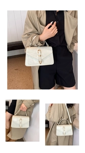 Detail of cream PU leather handbag with quilted stitching and gold U-shaped metal clasp