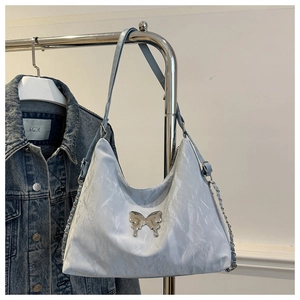 Detailed view of silver bow hardware and wrinkled texture on light blue tote bag