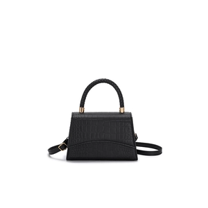Black croc-embossed square handbag with woven handle and gold hardware on white background
