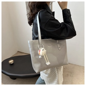 Grey PU tote bag detail with plush doll pendant and Fashion & Bags Leather text