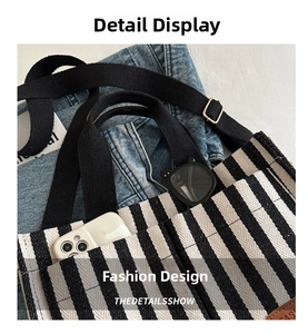 Detail of striped canvas tote showing black and white texture and front phone pocket