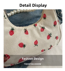 Close-up of strawberry print corduroy bag with decorative large pearl chain handle