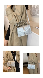 Detailed view of silver textured small square bag with golden U-shaped buckle and strap