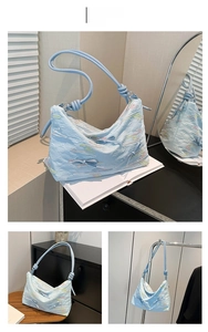 Detail of light blue textured shoulder bag with colorful wave embroidery and rope knot strap