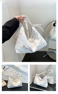 Detail of white tote bag with colorful wave embroidery and side bow decoration