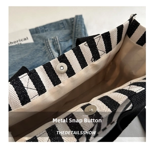 Detail of magnetic snap closure and striped canvas fabric on large tote bag
