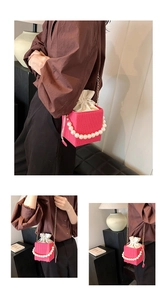 Detail of rose pink box bag with pearl handle, drawstring liner, and golden chain strap
