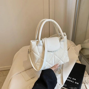 Minimalist white quilted bucket handbag with crossbody strap and top handle style