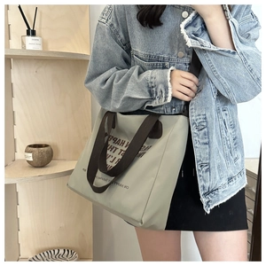Detail view of the printed canvas tote bag worn by a model in a casual lifestyle setting
