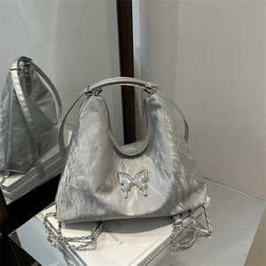 Silver pleated metallic backpack with butterfly charm and chain detail on book
