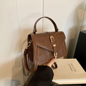 Brown vintage leather top-handle crossbody bag with elegant gold metal buckle hardware