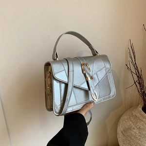 Silver metallic crossbody bag with geometric stitching and elegant metal buckle handle