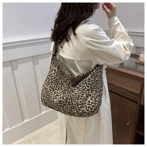 Detail shot of the integrated shoulder strap and thick canvas leopard print tote bag