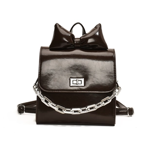Deep brown patent leather backpack with large bow detail and silver metal chain accessory