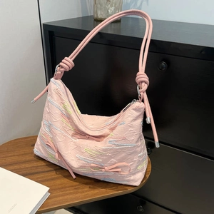 Pink minimalist tote bag with wave embroidery and 3D bows shown against a vintage cabinet