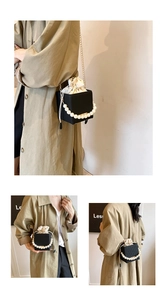 Detail of black pearl handle bucket bag featuring texture and drawstring inner pouch