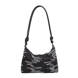 Minimalist black tote bag featuring colorful wave embroidery and bow details on white background