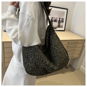Macro detail of dark green leopard print canvas tote bag with textured hobo style fabric