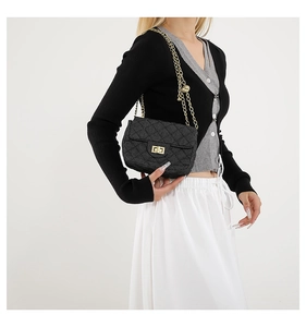 Detail der schwarzen Stepptasche mit goldener Kette und Metall-Drehverschluss