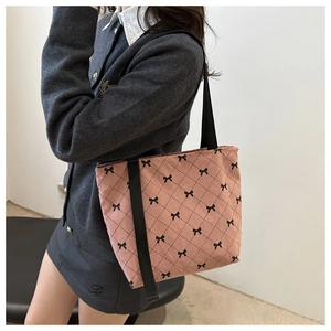 Vue détaillée du sac cabas en velours côtelé rose avec nœuds noirs et motif à carreaux