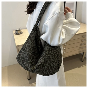 Detail view of large leopard print hobo bag with vintage green base and canvas texture