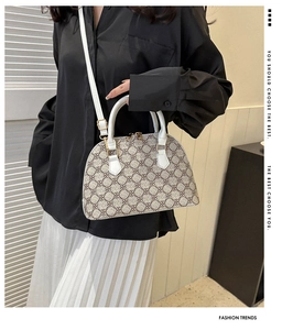 Detail view of the quilted shell crossbody bag with adjustable white leather strap and gold hardware