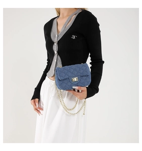 Blaue Denim Umhängetasche mit Rautensteppung und goldener Kette am Model gezeigt