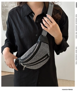 Detail of black crossbody bag with rhinestone embellishments and woven strap