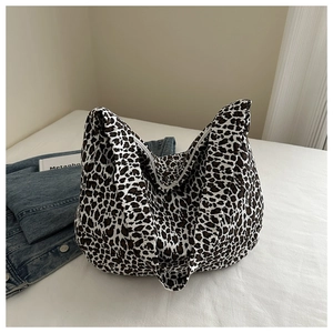 Detail of large leopard print canvas tote bag with wide strap and soft moon shape texture