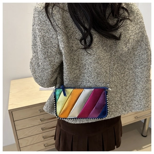 Close-up of rainbow striped crossbody bag with silver bead trim and metal chain strap