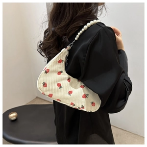 Detail of corduroy dumpling bag with strawberry embroidery and pearl chain strap