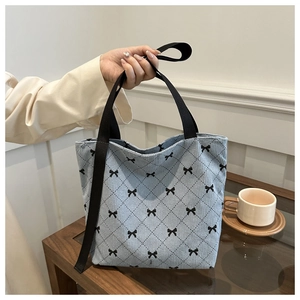 Détail du sac cabas en velours côtelé bleu clair avec broderie de nœuds noirs chic