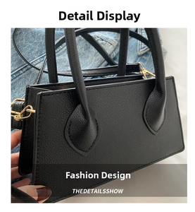 Detail of black lychee grain texture on leather handbag with gold metal hardware hooks