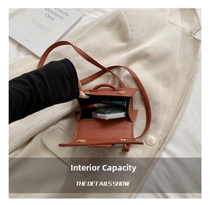 Interior storage space of the brown leather mini crossbody bag showing cosmetic items