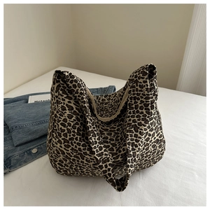 Close-up of leopard print canvas tote bag with thick fabric handles on white background